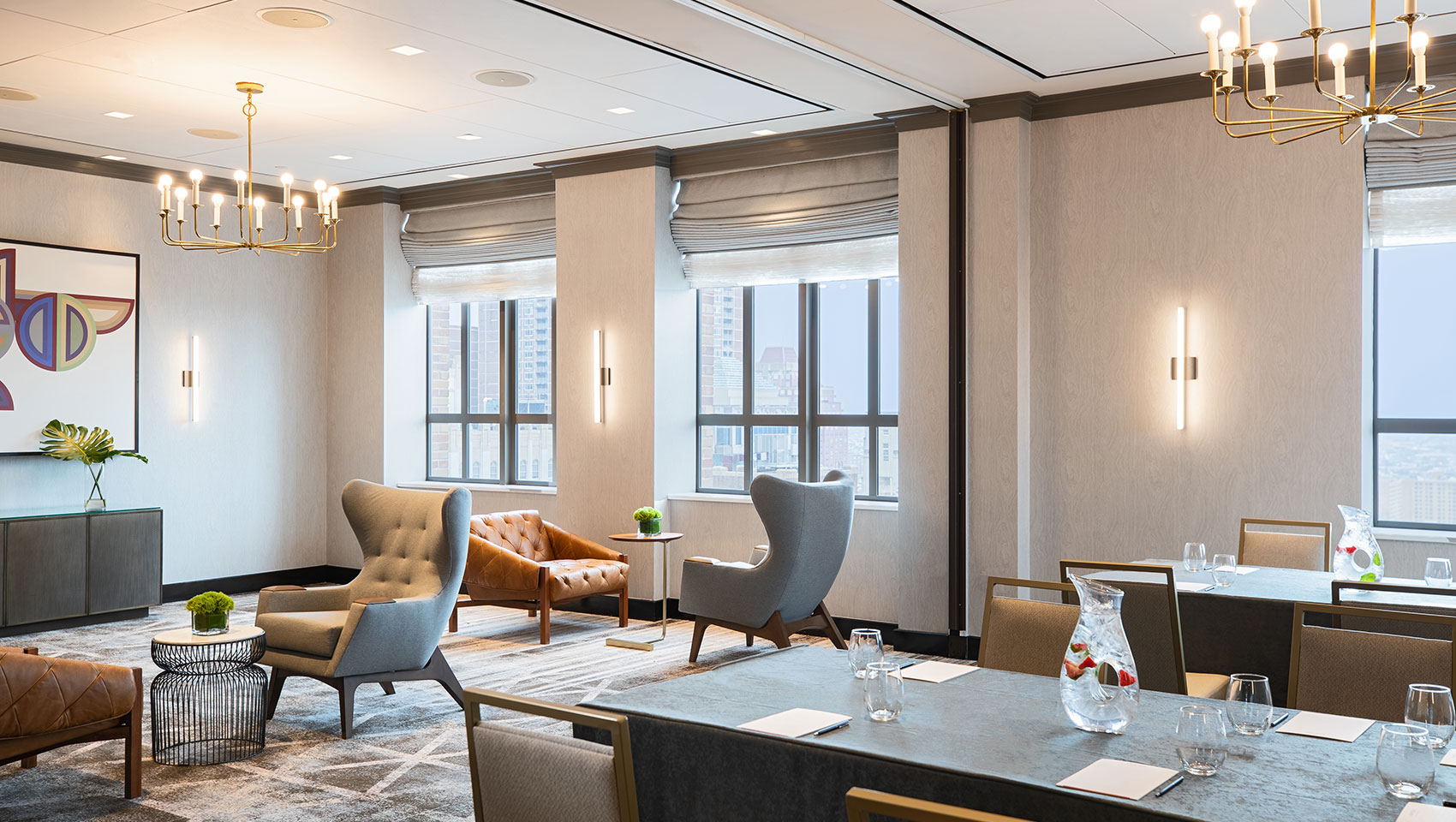 Cret room at Kimpton Hotel Palomar Philadelphia in a brainstorm set up with a long table with notepads to one side and comfortable face-to-face chairs on the other, all encompassed within a room with multiple large windows and city views