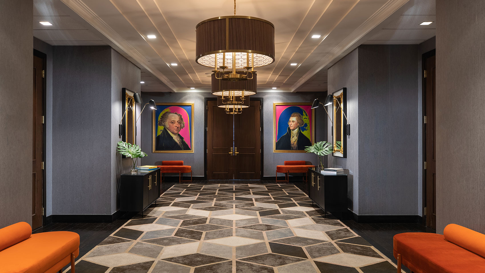 Kimpton Hotel Palomar Philadelphia 24th floor meeting + event foyer area showing geometric carpet in open area, brightly colored plush seating, and a series of circular lighting fixtures 