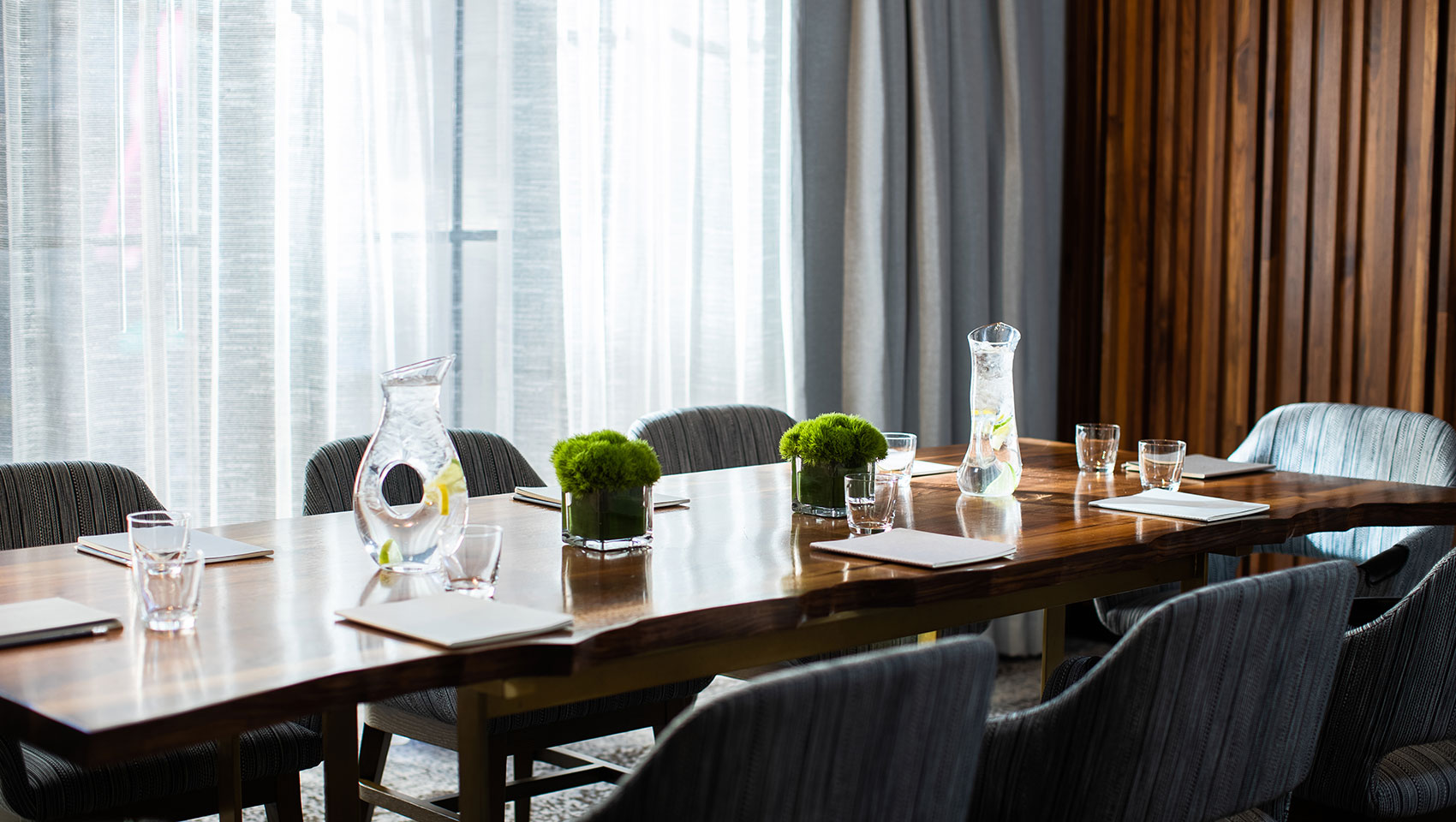 Boardroom Calder at Kimpton Hotel Palomar Philadelphia showing long, wood boardroom table with notepads and drinking glasses