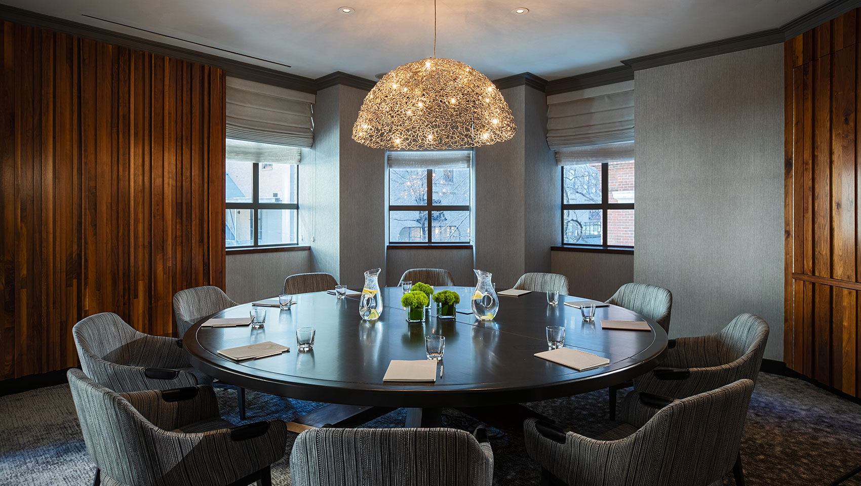 Boardroom Pei at Kimpton Hotel Palomar Philadelphia with large round table that has notepads and glassware on top, all situated underneath unique lighting fixture