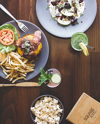 Lunch Table with burger, salad, popcorn, and drinks