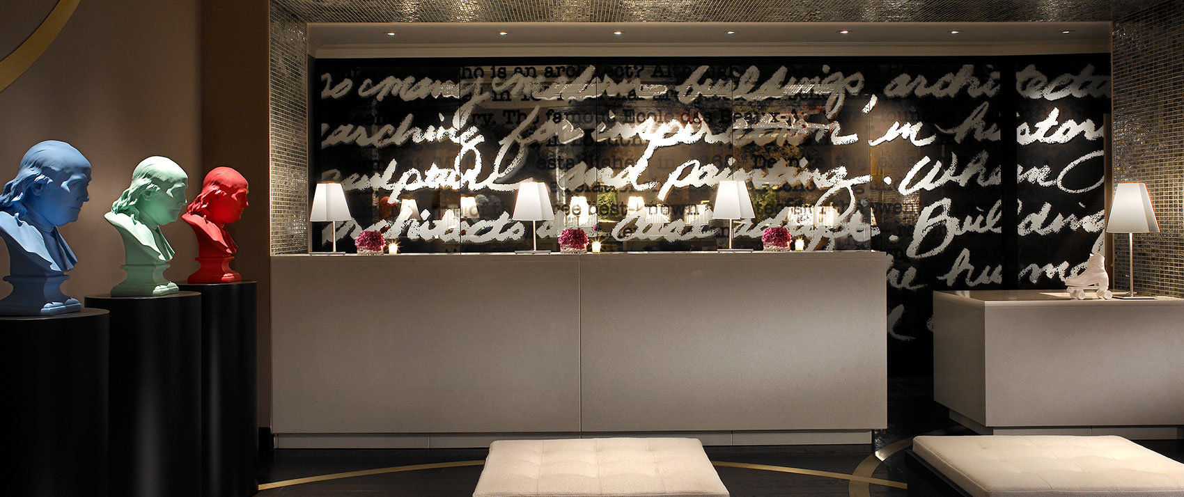 Kimpton Hotel Palomar Philadelphia lobby showing front desk with multi-colored statues to the left and ottoman seating