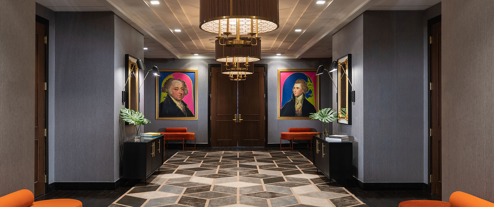 Kimpton Hotel Palomar Philadelphia 24th floor meeting + event foyer area showing geometric carpet in open area, brightly colored plush seating, and a series of circular lighting fixtures